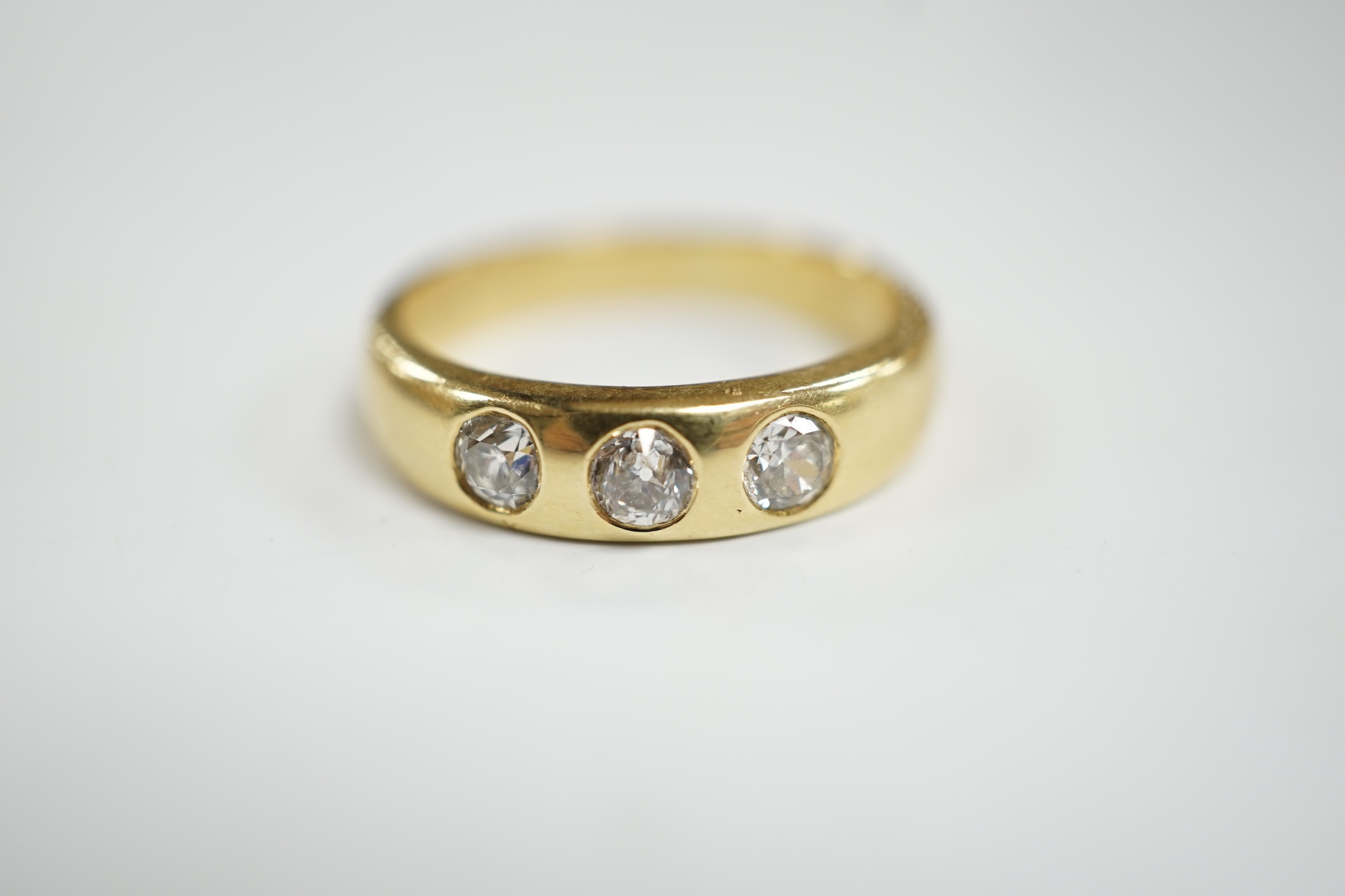 A modern 18ct gold and gypsy set three stone diamond ring, size R, gross weight 7.6 grams.